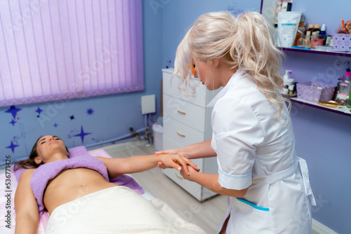 Blonde massage therapist massaging a woman. Woman getting a massage at the spa