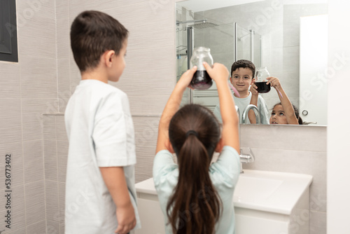 Keen children grow crystals, and watch crystallization solution in glass jar .