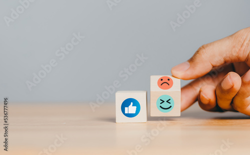 Social and digital media network concept. hand filp wood cube comment emotion like, love, angry. online marketing, technology network concept. photo