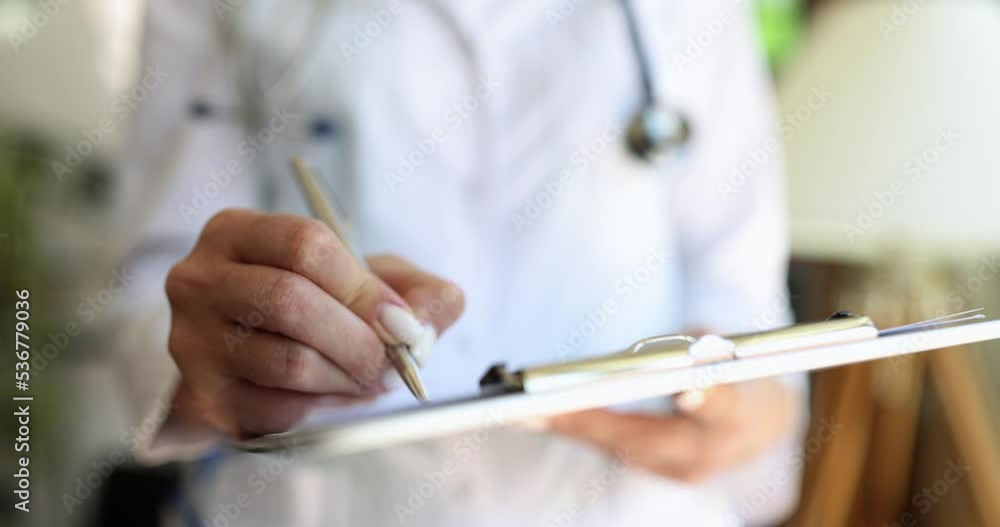 Doctor with stethoscope writes in patient chart and makes notes Doctor with stethoscope writes in patient chart and makes notes