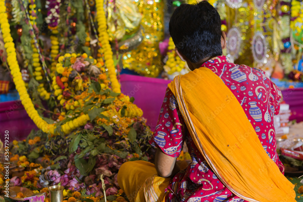 puja rituals being performed by hindu priest with flowers and other condiments during kali puja