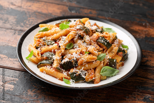 Zucchini penne pasta with parmesan cheese, basil and tomato. Healthy food