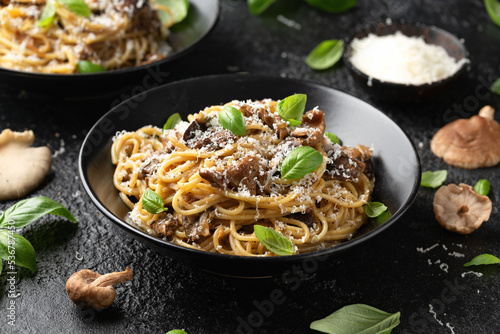 Porcini and woodland mushrooms pasta with pecorino cheese, basil in black bowl