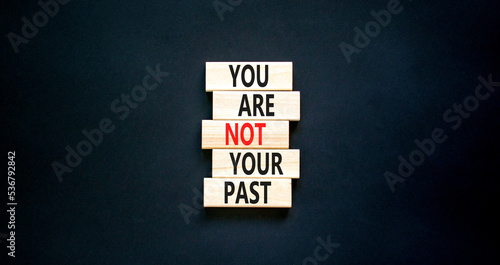 You are not your past symbol. Concept words You are not your past on wooden blocks. Beautiful black table black background. Business and you are not your past concept. Copy space.