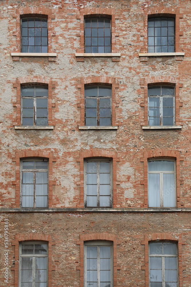red bricks and old peeling windows of an old industrial building