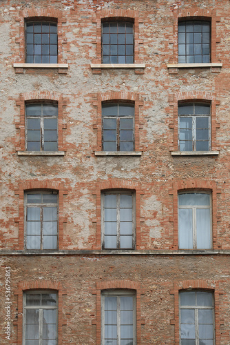 red bricks and old peeling windows of an old industrial building