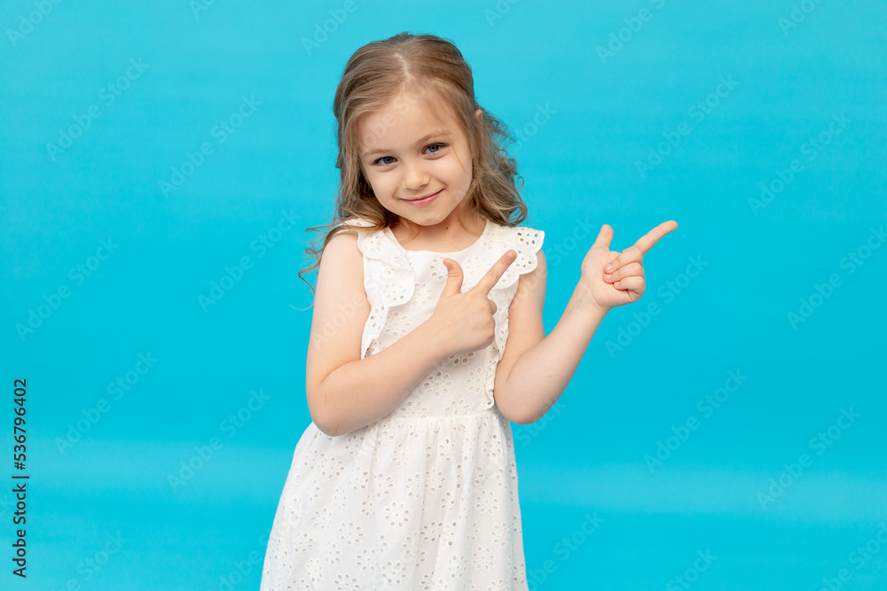 Happy cute little girl in a cotton white dress on a blue background in ...