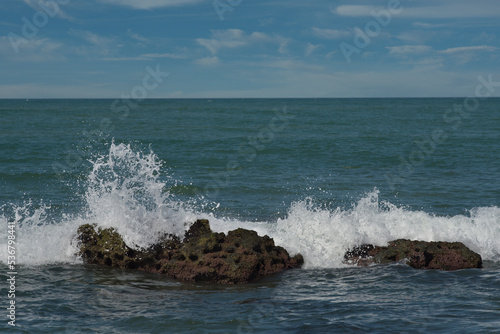 West Africa. Senegal. The waves of the Atlantic Ocean beat against the rocks of volcanic origin on the beach of the resort town of Ngaparou. photo