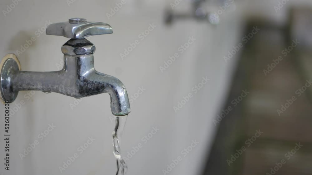 water flowing from the iron faucet with a blurry background water flowing from the iron faucet with a blurry background