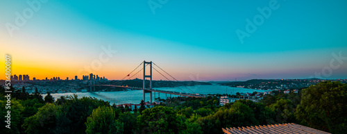 ISTANBUL, TURKEY. Panoramic view of Istanbul Bosphorus on sunset. Istanbul Bosphorus Bridge (15 July Martyrs Bridge. Turkish: 15 Temmuz Sehitler Koprusu). Beautiful cloudy blue sky. photo