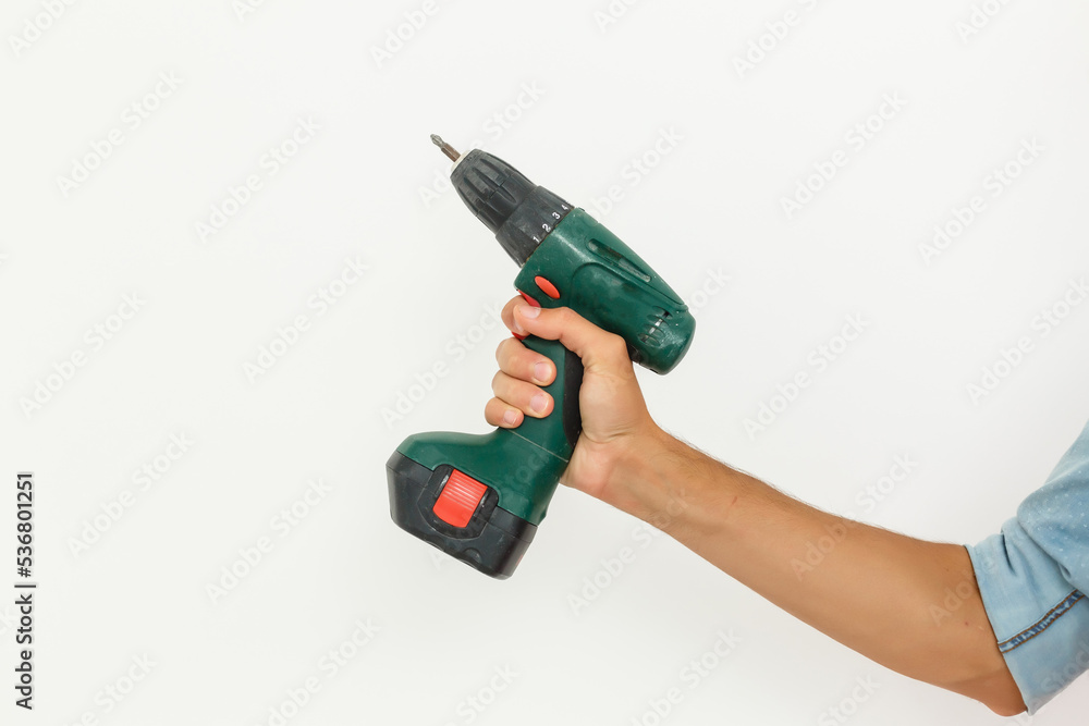 Cordless screwdriver holding by hand with isolated white background. Cordless screwdriver holding by hand with isolated white background.