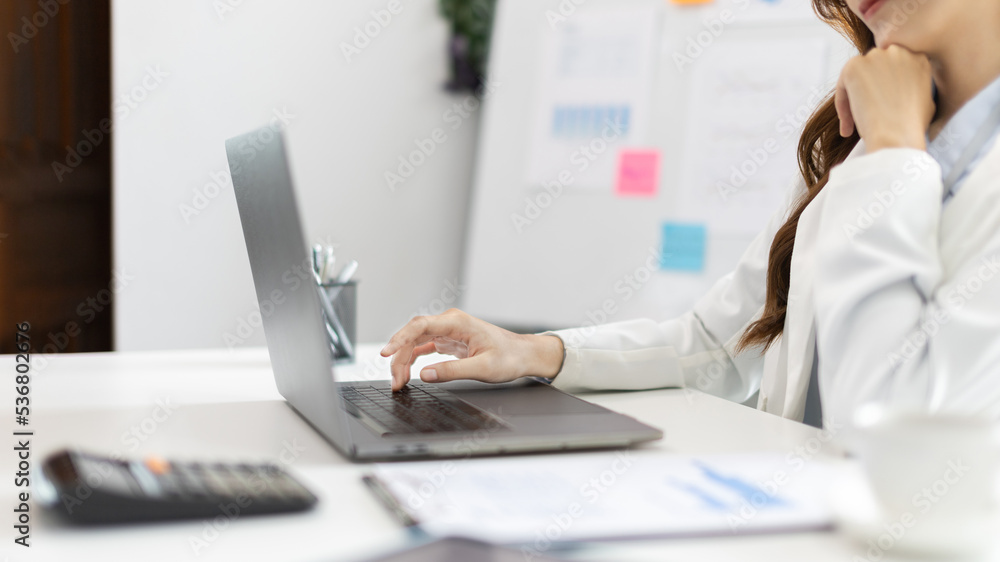 Businesswoman's hand presses on a laptop keyboard, World of technology and internet communication, Using computers to conduct financial transactions because the convenience and speed. Businesswoman's hand presses on a laptop keyboard, World of technology and internet communication, Using computers to conduct financial transactions because the convenience and speed.