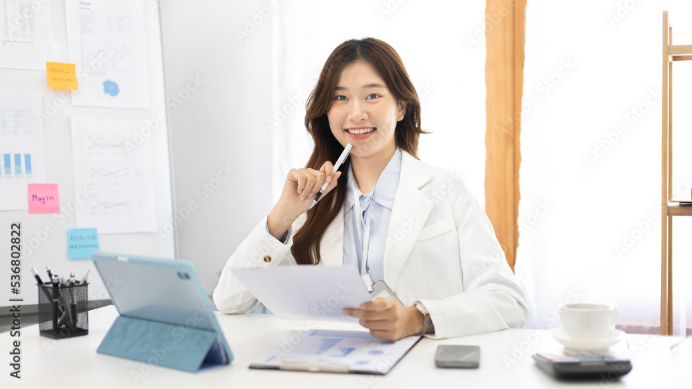 Businesswoman using laptop to work, Asian woman working in the office, Financial clerk or accountant with documents and equipment working on the desk, Using tablet for financial transactions. Businesswoman using laptop to work, Asian woman working in the office, Financial clerk or accountant with documents and equipment working on the desk, Using tablet for financial transactions.