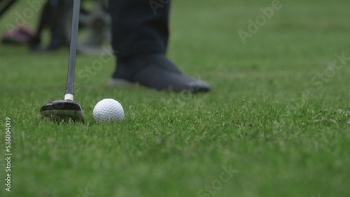 Extreme Close up Caucasian man playing golf, striking a ball during the course