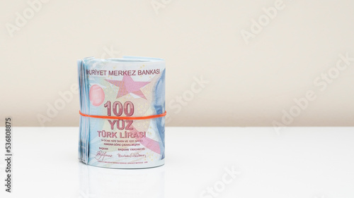 Hundred Turkish liras rolled up with rubber band on isolated white background