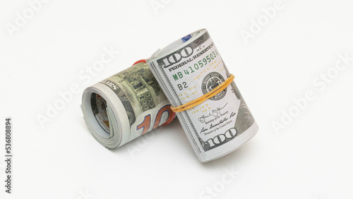 Hundred dollar bills rolled up with rubber band on isolated white background