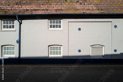Abstract view of an old Suffolk, UK Brewery warehouse seen in an empty street in late afternoon. The buildings is used in the process of beer brewing.