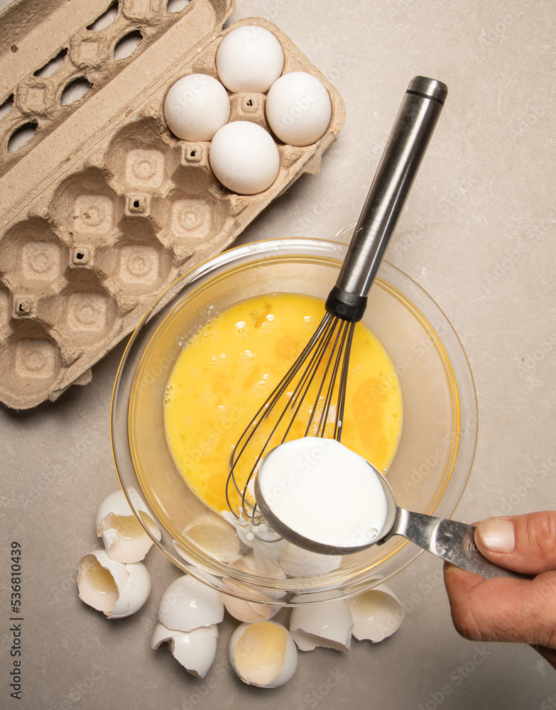 whisking eggs in glass mixing bowl whisking eggs in glass mixing bowl