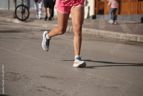 runner feet on the asphalt in a city race shoes mussles legs soprts © sea and sun