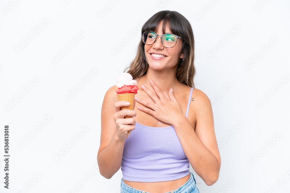 Young caucasian woman with a cornet ice cream over isolated white background looking up while smiling Young caucasian woman with a cornet ice cream over isolated white background looking up while smiling