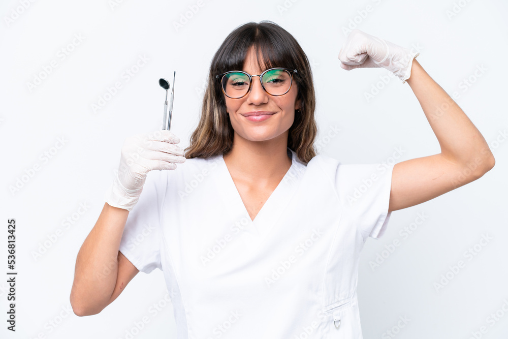 Dentist caucasian woman holding tools isolated on white background doing strong gesture Dentist caucasian woman holding tools isolated on white background doing strong gesture