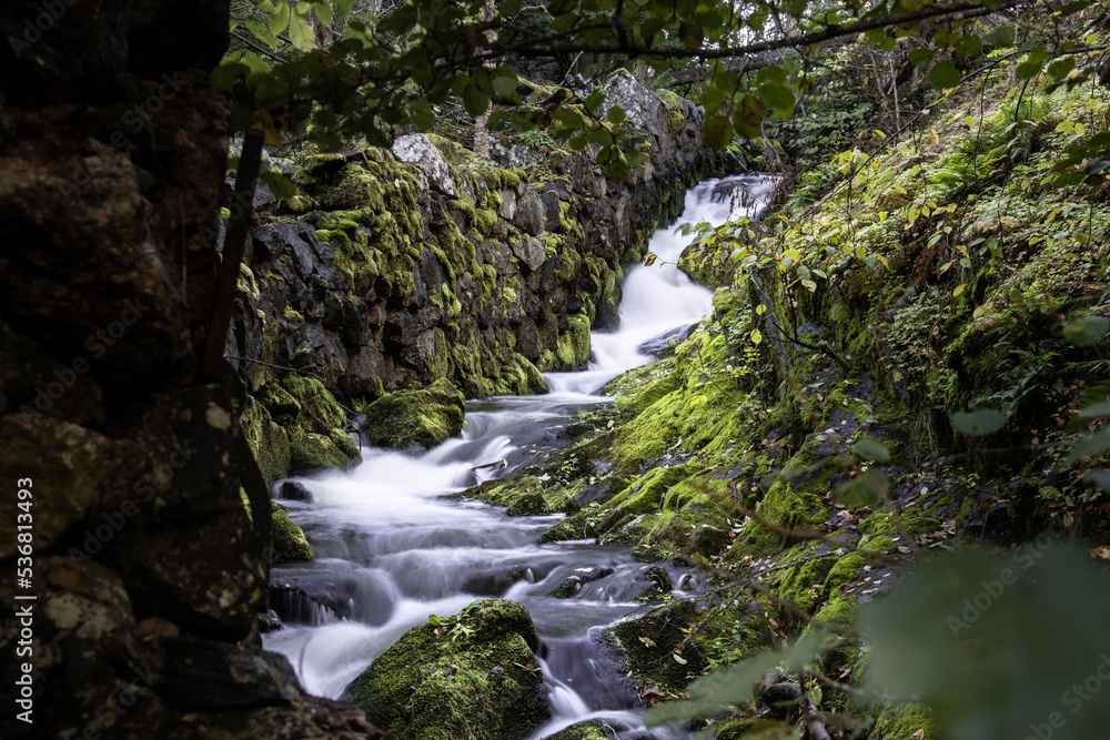 waterfall in a swedish autumn forest the forest next to a stone wall