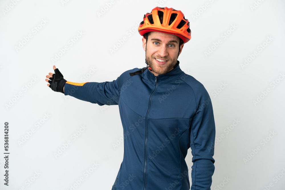 Young cyclist man isolated on white background extending hands to the side for inviting to come Young cyclist man isolated on white background extending hands to the side for inviting to come