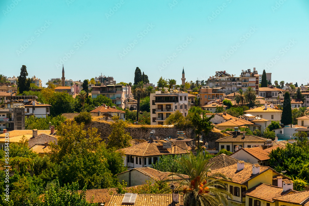 Roofs of a Mediterranean town against the background of the blue sea and mountains in the distance. The concept of a holiday at the sea in summer.