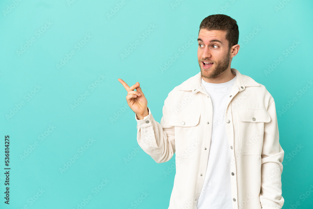 Handsome blonde man over isolated blue background intending to realizes the solution while lifting a finger up Handsome blonde man over isolated blue background intending to realizes the solution while lifting a finger up