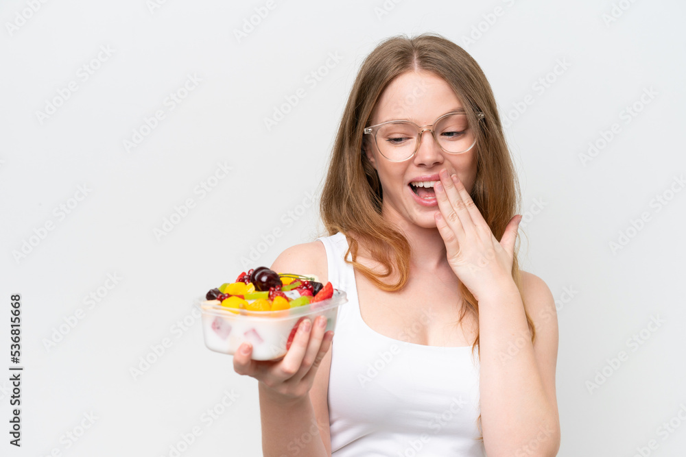 Young pretty woman holding a bowl of fruit isolated on white background with surprise and shocked facial expression Young pretty woman holding a bowl of fruit isolated on white background with surprise and shocked facial expression