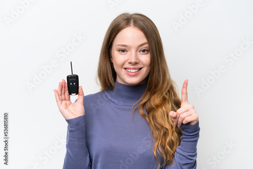 Young caucasian woman holding car keys isolated on white background pointing up a great idea
