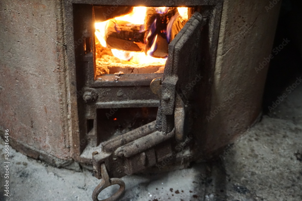 Alter runder grauer Bauernkessel mit brennendem Feuer Alter runder grauer Bauernkessel mit brennendem Feuer