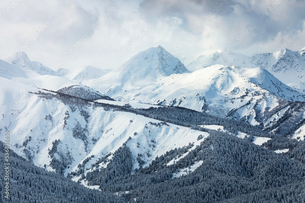Snow covered mountain peaks in the clouds
