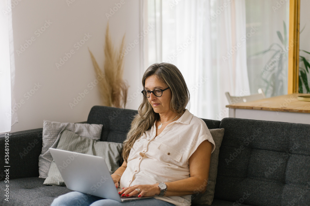 Adult woman working from home using laptop Adult woman working from home using laptop