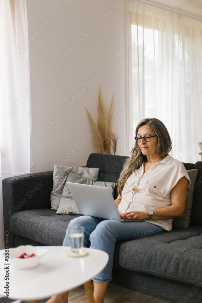 Adult woman working from home using laptop Adult woman working from home using laptop