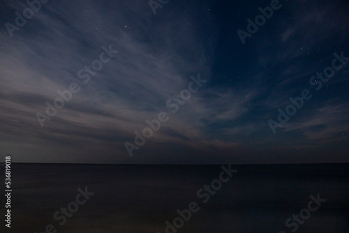 Starry sky with clouds and sea in the evening in autumn