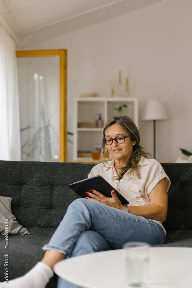 Obraz premium Adult woman having video call at home using tablet