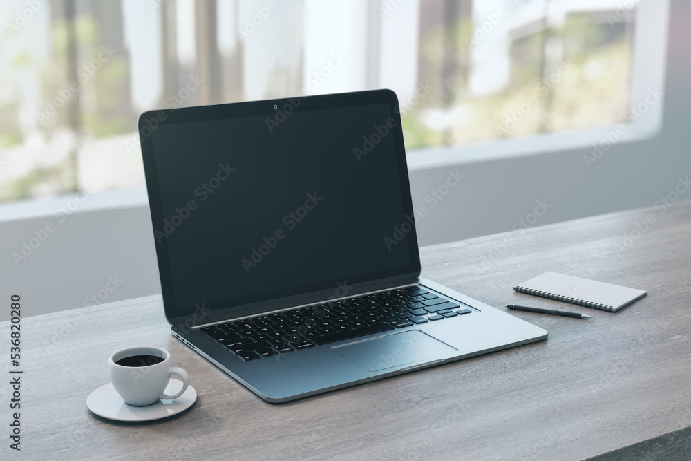 Close up of empty laptop on wooden desktop with coffee cup, notepad, pen, mock up place on screen, blurry office interior with window and city view background. 3D Rendering. Close up of empty laptop on wooden desktop with coffee cup, notepad, pen, mock up place on screen, blurry office interior with window and city view background. 3D Rendering.