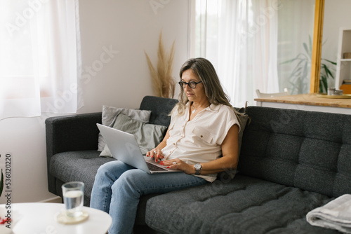 Adult woman using laptop at home