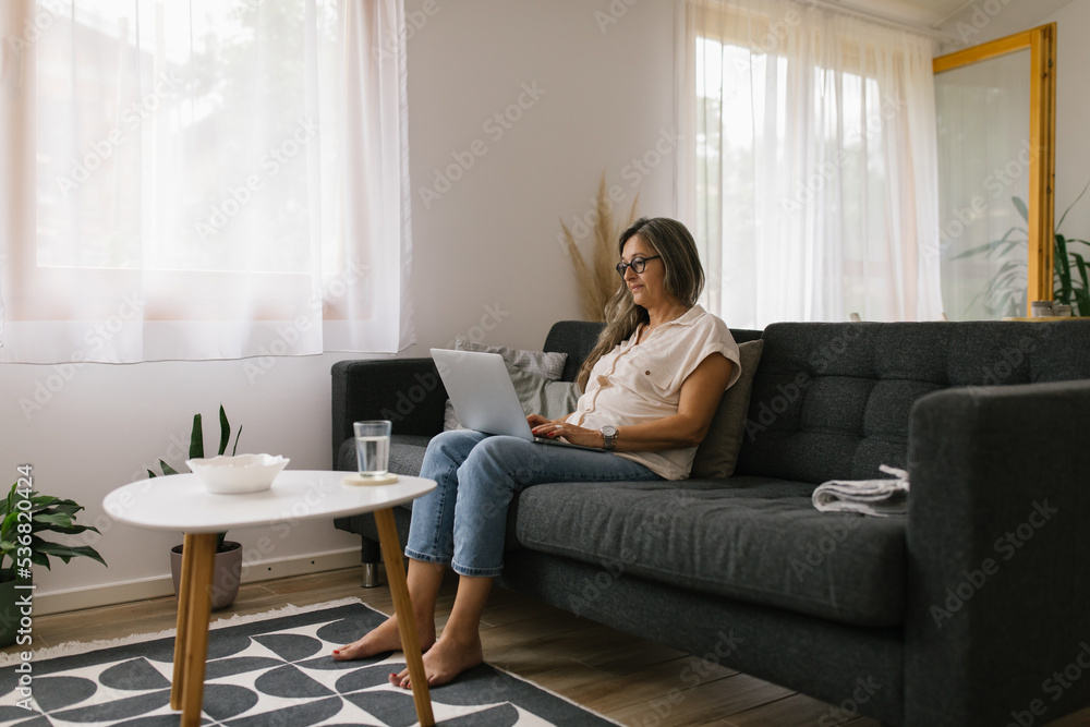 Adult woman using laptop at home Adult woman using laptop at home