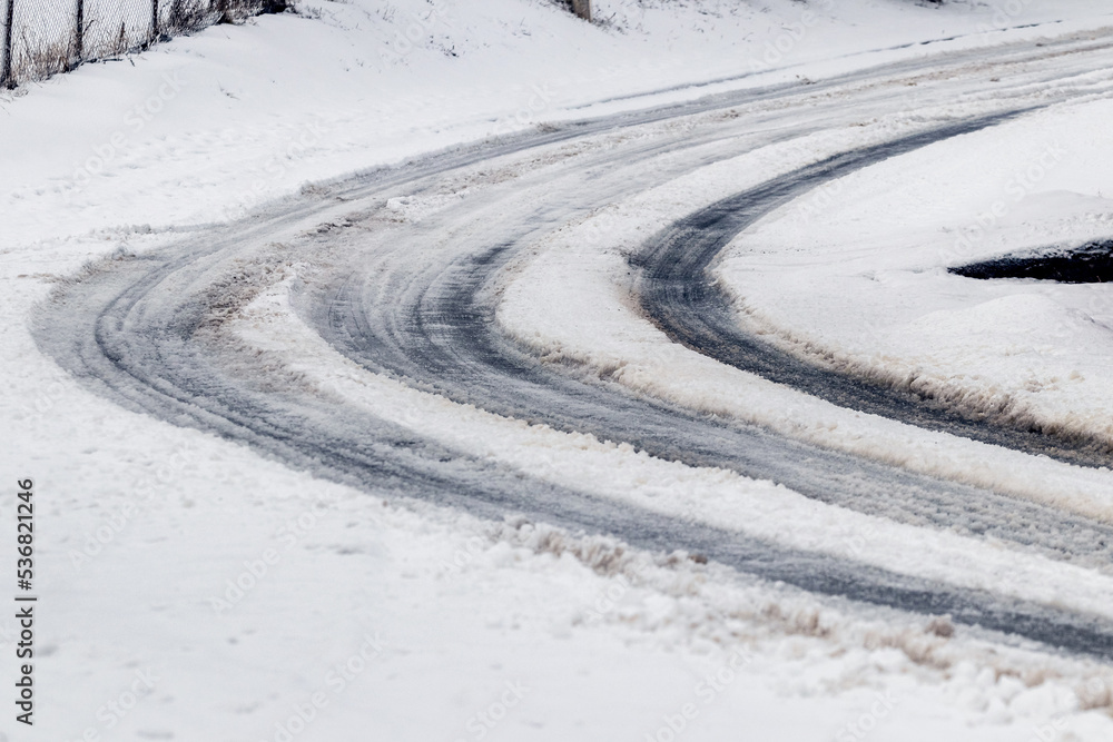 Traces of the car on a snowy road in winter