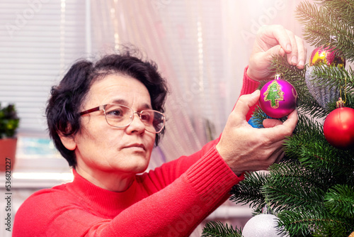 A woman decorates a Christmas and New Year tree. Preparation for Christmas and New Year