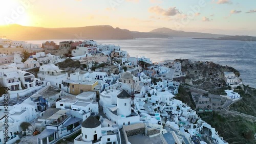 Santorini island in Greece, aerial view of famous Oia town on Santorini at sunrise, Greek tourist destination, windmill in Oia, Santorini