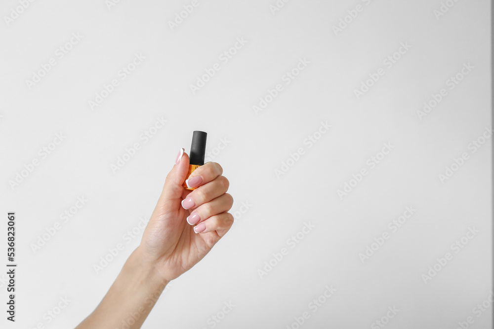 Girl with beautiful long nails hold gel nail polish on a white background Girl with beautiful long nails hold gel nail polish on a white background