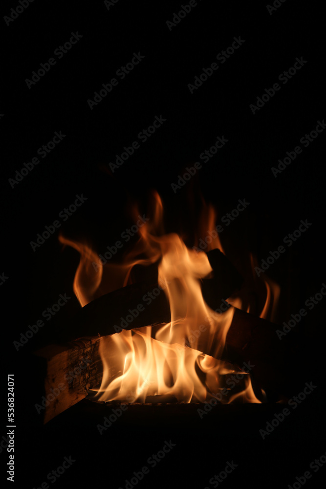 Bonfire burning and bringing in some heat, light and lovely atmosphere. Enjoy the fire in fireplace, as a campfire or simply as a background image. Closeup of abstract red, orange and yellow flames.