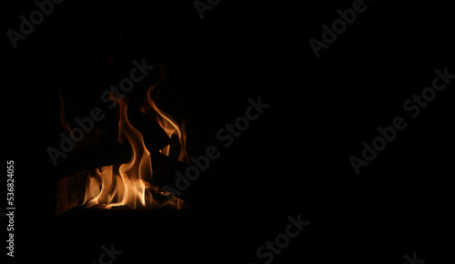 Bonfire burning and bringing in some heat, light and lovely atmosphere. Enjoy the fire in fireplace, as a campfire or simply as a background image. Closeup of abstract red, orange and yellow flames. © Nora
