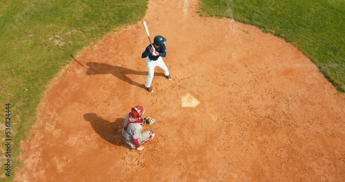 OVERHEAD Batter baseball player hits a ball over a home plate