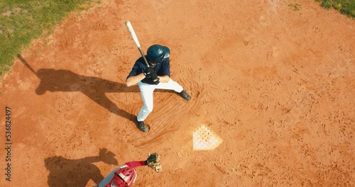 Photography OVERHEAD Batter baseball player hits a ball over a home plate