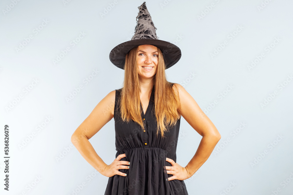 Happy brunette woman in halloween witch costume with black hat Happy brunette woman in halloween witch costume with black hat
