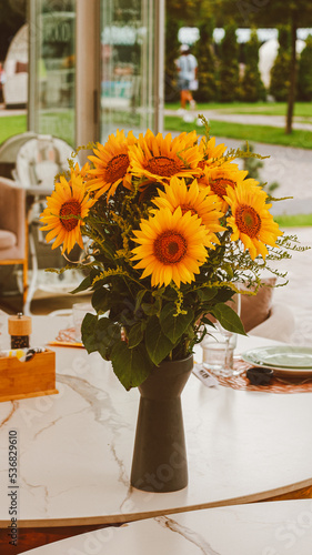 sunflower in a vase on a table in a restaurant